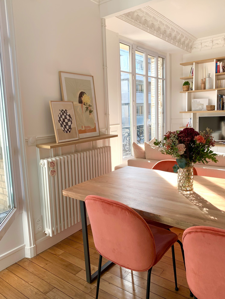 Foto di una sala da pranzo aperta verso il soggiorno design di medie dimensioni con pareti bianche, parquet chiaro, pavimento marrone e boiserie