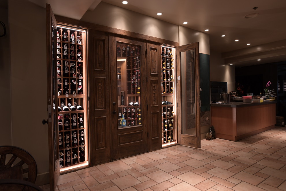 Photo of a mid-sized country wine cellar in San Diego with porcelain floors and display racks.