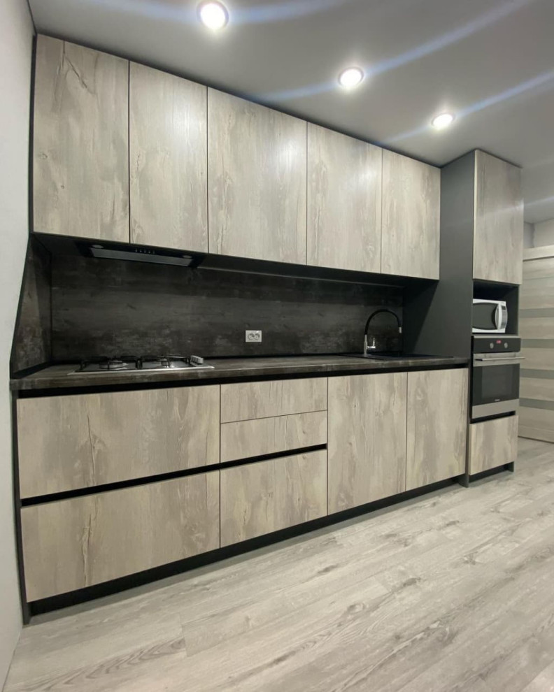 This is an example of a small scandinavian single-wall separate kitchen in Moscow with a drop-in sink, recessed-panel cabinets, light wood cabinets, solid surface benchtops, brown splashback, metal splashback, stainless steel appliances, linoleum floors, no island, brown floor and brown benchtop.