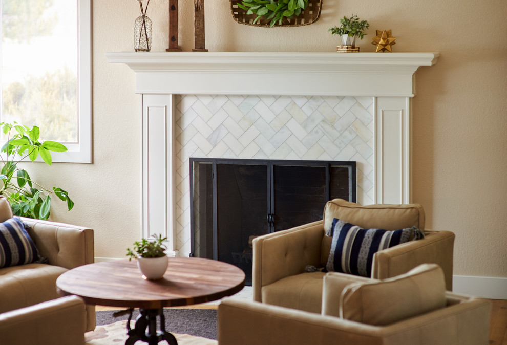 Photo of a mid-sized transitional formal open concept living room in Denver with beige walls, light hardwood floors, a standard fireplace, a tile fireplace surround, no tv and brown floor.