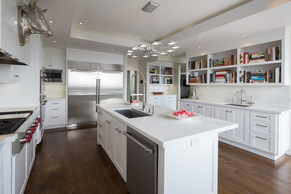 Transitional u-shaped kitchen in San Francisco with an undermount sink, recessed-panel cabinets, white cabinets, white splashback, stainless steel appliances, dark hardwood floors and with island.