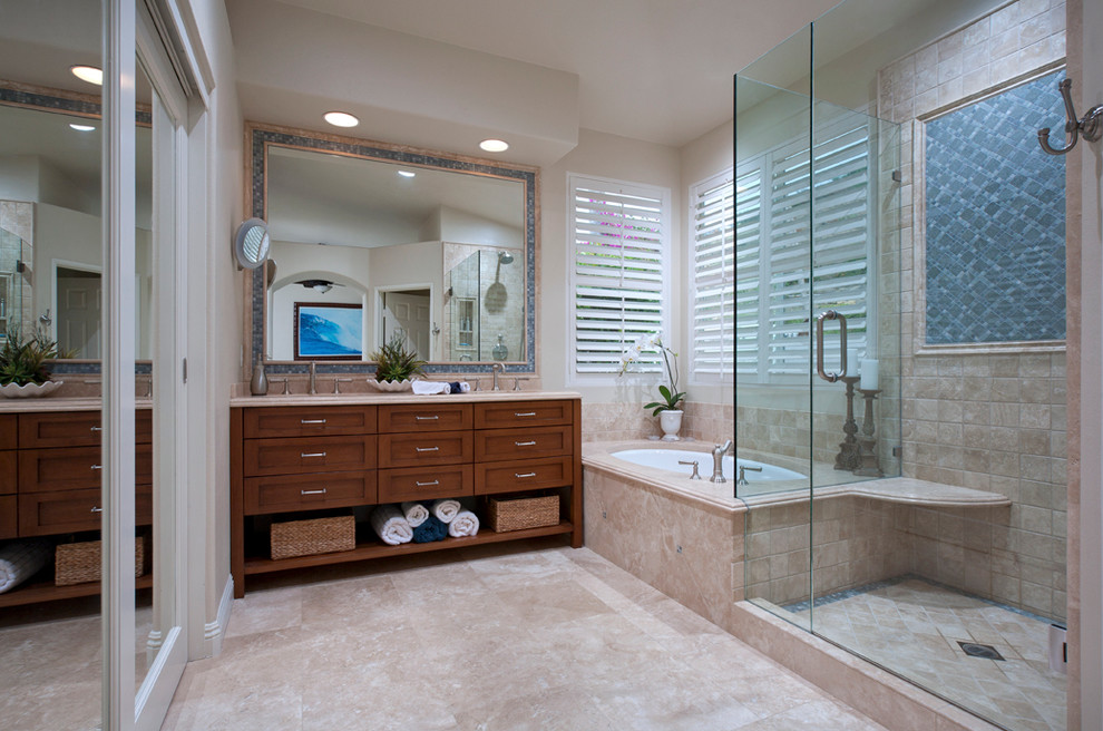 Large traditional master bathroom in Orange County with a drop-in sink, beaded inset cabinets, medium wood cabinets, granite benchtops, a shower/bathtub combo, a one-piece toilet, white tile, ceramic tile, beige walls, marble floors, an undermount tub, beige floor, a hinged shower door and beige benchtops.