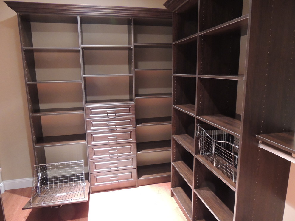Mid-sized traditional gender-neutral walk-in wardrobe in Philadelphia with raised-panel cabinets and brown cabinets.