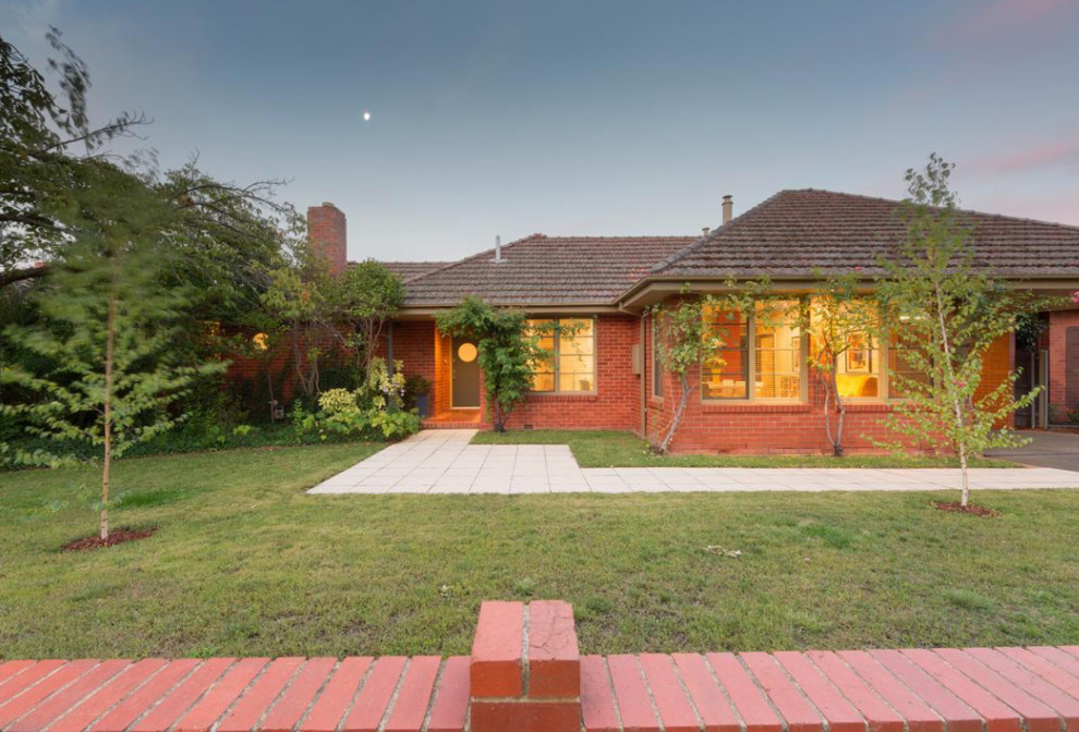 Inspiration for a large midcentury one-storey brick red house exterior in Canberra - Queanbeyan with a gable roof and a tile roof.