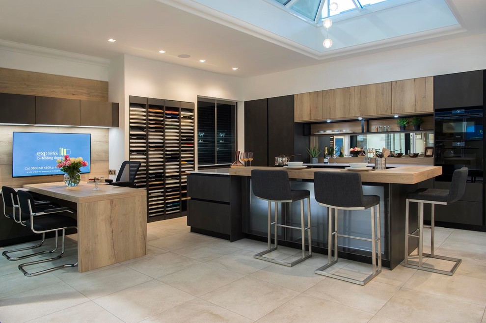 Photo of a large contemporary galley eat-in kitchen in Other with an integrated sink, flat-panel cabinets, grey cabinets, quartzite benchtops, metallic splashback, mirror splashback, black appliances, ceramic floors, with island, beige floor and white benchtop.