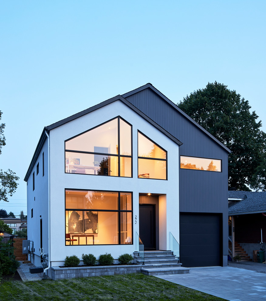 Inspiration pour une façade de maison grise nordique en stuc à un étage avec un toit à deux pans, un toit en shingle et un toit noir.