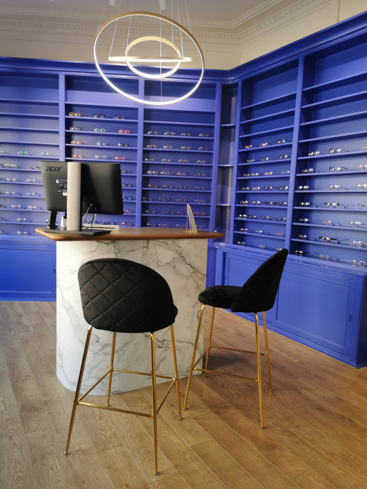 Cette image montre un grand salon design avec une salle de réception, un mur bleu, sol en stratifié et du papier peint.