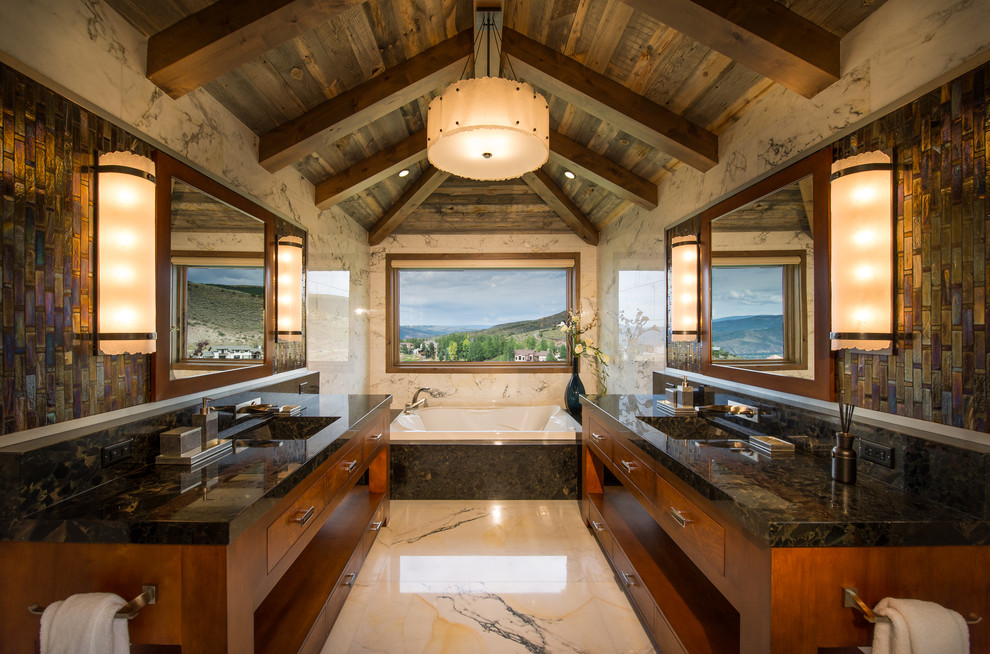 Inspiration for a large country master bathroom in Denver with flat-panel cabinets, medium wood cabinets, multi-coloured tile, an undermount sink, granite benchtops and a drop-in tub.