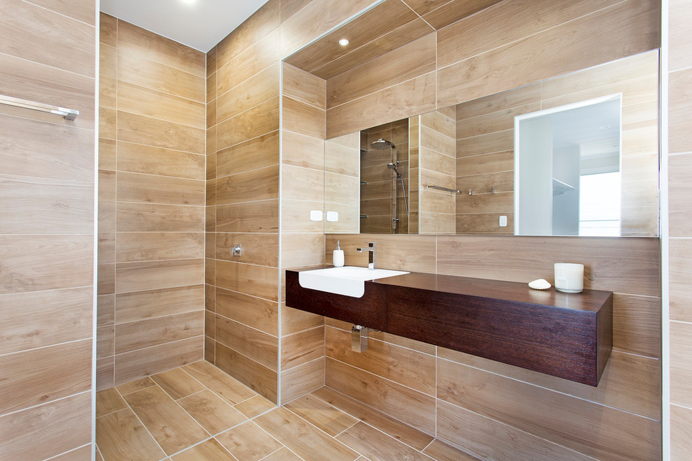 This is an example of a mid-sized contemporary master bathroom in Gold Coast - Tweed with an integrated sink, dark wood cabinets, wood benchtops, an open shower, a wall-mount toilet, ceramic tile and ceramic floors.