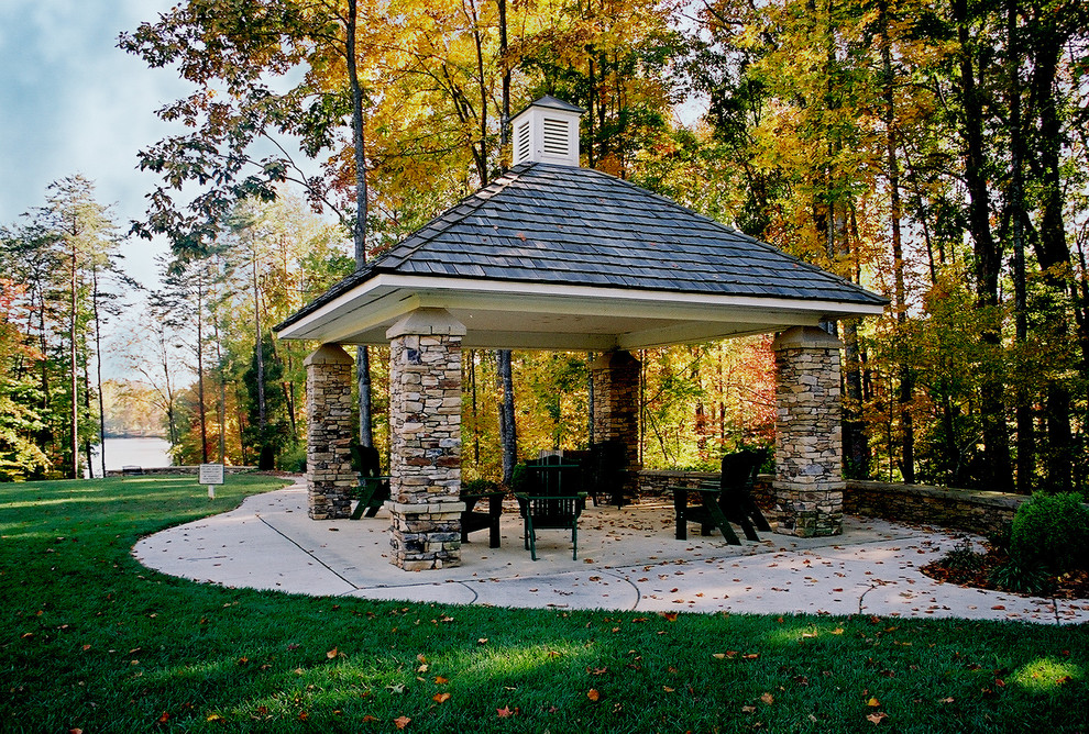 Photo of a mid-sized traditional courtyard patio in Other with natural stone pavers and a gazebo/cabana.