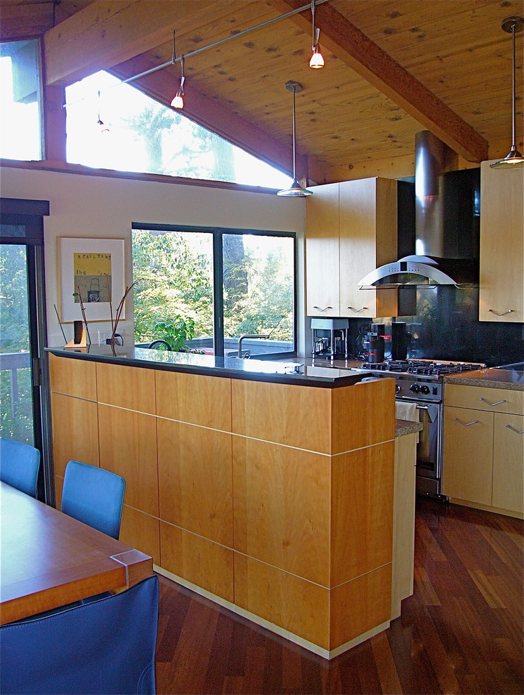 This is an example of a small midcentury u-shaped eat-in kitchen in San Francisco with an undermount sink, flat-panel cabinets, light wood cabinets, granite benchtops, black splashback, stone slab splashback, stainless steel appliances, dark hardwood floors and a peninsula.