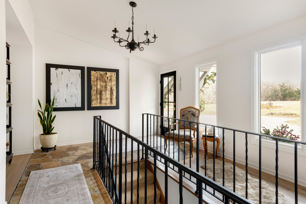 Mid-sized transitional slate floor, brown floor and vaulted ceiling single front door photo in Minneapolis with white walls and a black front door