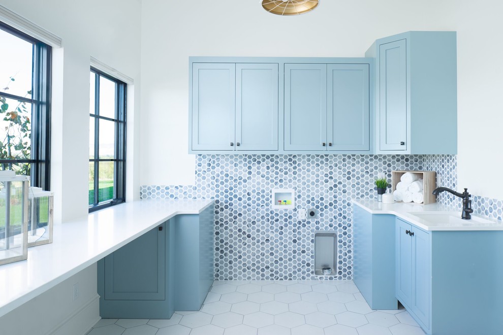 This is an example of an eclectic u-shaped dedicated laundry room in Boise with an undermount sink, shaker cabinets, blue cabinets, white walls, ceramic floors, white floor and white benchtop.