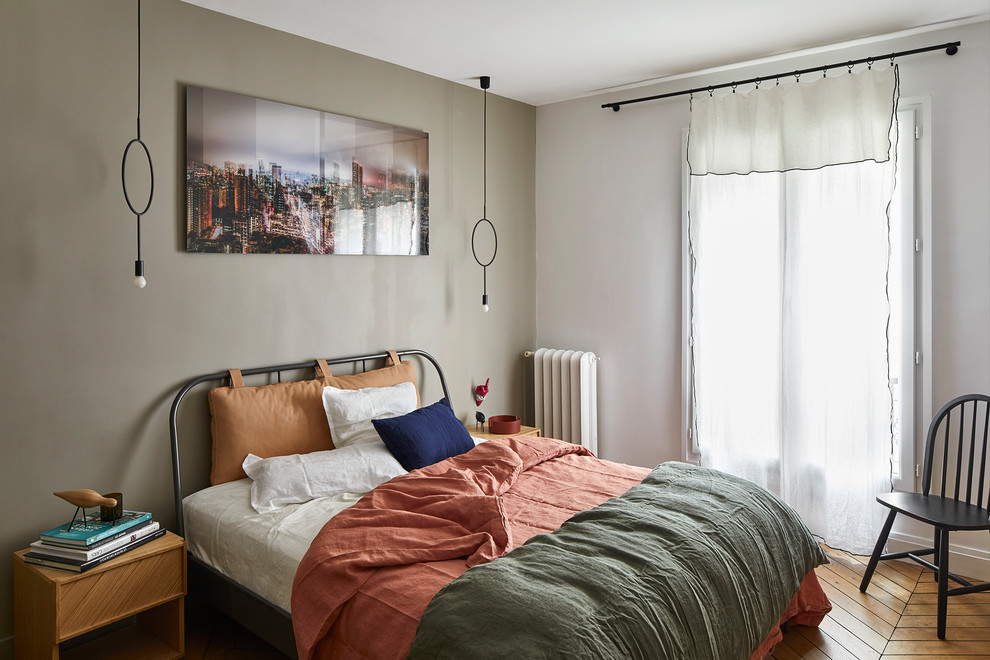 Design ideas for a mid-sized scandinavian master bedroom in Paris with beige walls and light hardwood floors.