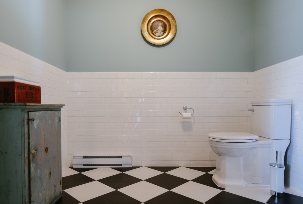 Design ideas for a mid-sized eclectic powder room in Montreal with white tile, subway tile, blue walls, porcelain floors, a console sink, black floor and solid surface benchtops.