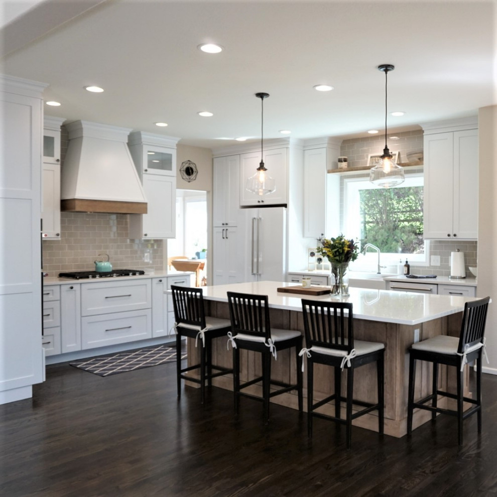 Open concept kitchen - large transitional l-shaped open concept kitchen idea in Denver with a farmhouse sink, shaker cabinets, quartz countertops, glass tile backsplash, white appliances, an island and white countertops