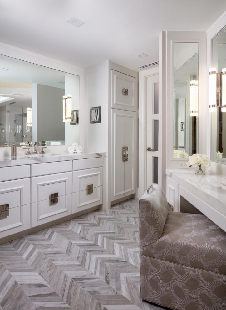 This is an example of a large beach style master bathroom in Miami with raised-panel cabinets, white cabinets, a corner shower, a bidet, white tile, porcelain tile, grey walls, marble floors, an undermount sink, marble benchtops, grey floor, a hinged shower door, white benchtops, a shower seat, a double vanity and a built-in vanity.