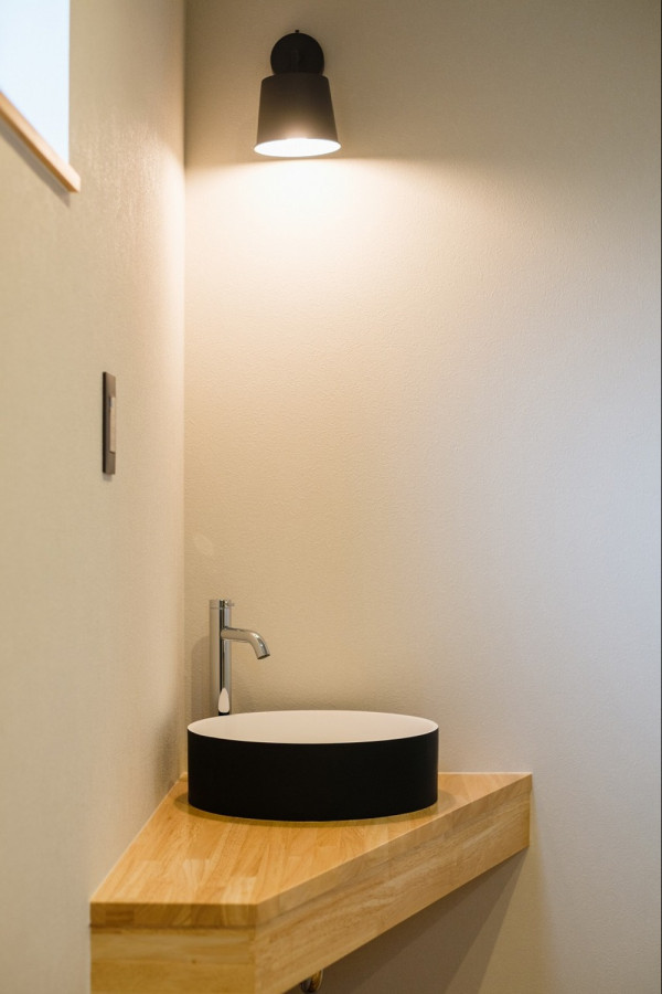Réalisation d'un WC et toilettes en bois clair avec un mur blanc, un plan de toilette en bois, un plan de toilette beige, meuble-lavabo sur pied, un plafond en papier peint et du papier peint.