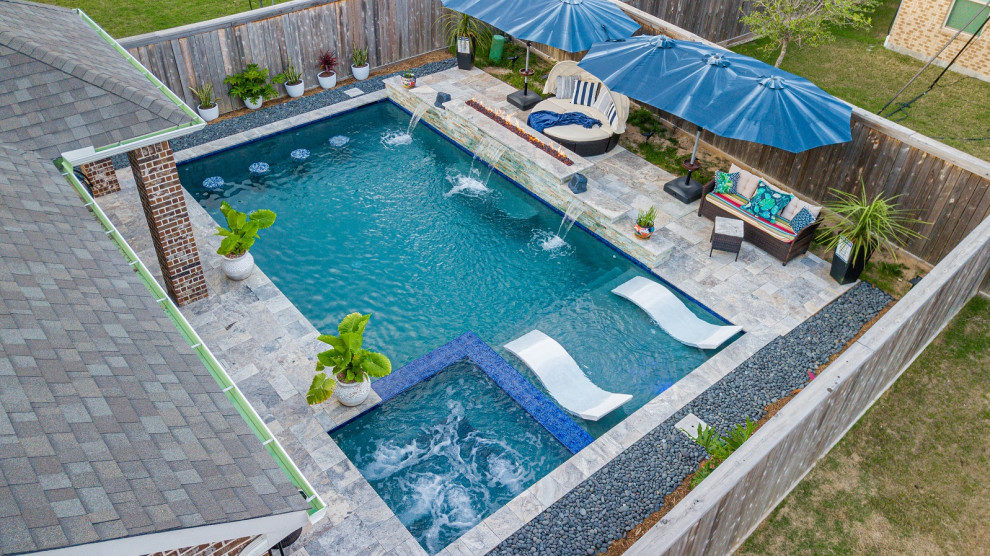 На фото: прямоугольный бассейн среднего размера на заднем дворе в морском стиле с покрытием из каменной брусчатки с