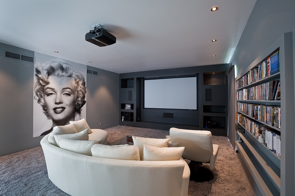 Mid-sized modern enclosed home theatre in Los Angeles with grey walls, carpet, a projector screen and grey floor.
