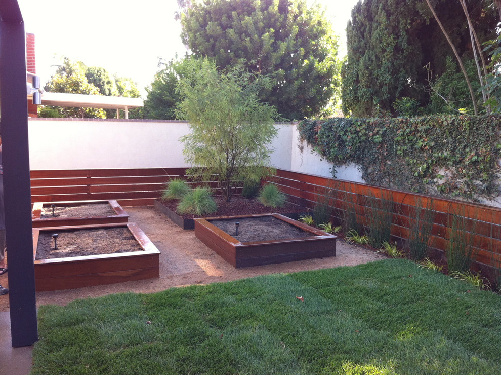 This is an example of a mid-sized modern backyard patio in Orange County with a vegetable garden, no cover and concrete slab.