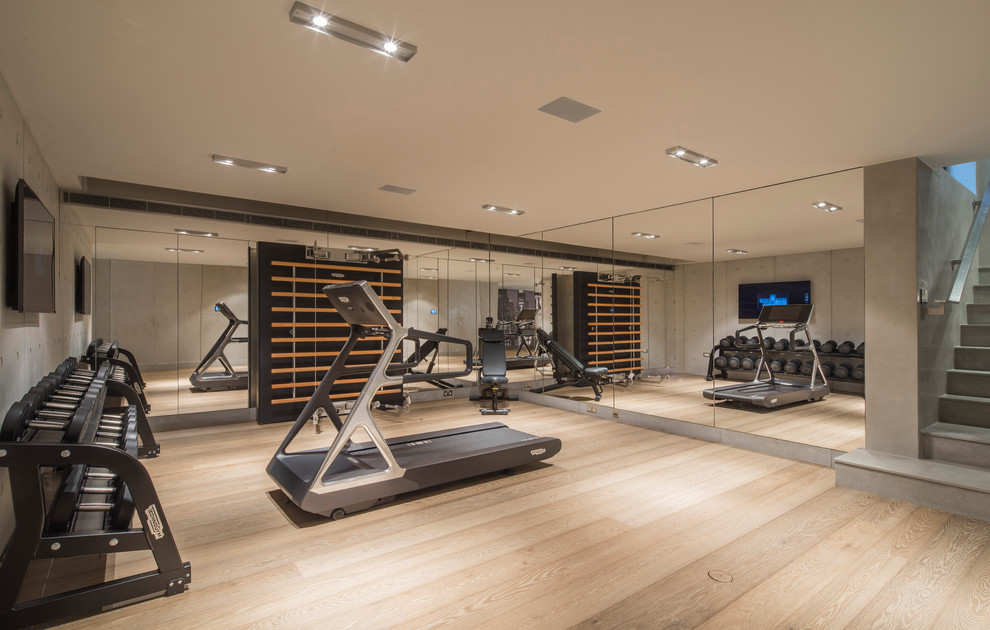 Inspiration for a large contemporary multipurpose gym in London with light hardwood floors and grey walls.