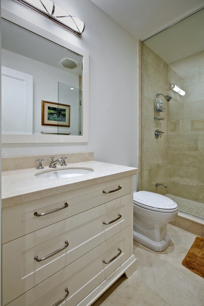 This is an example of a mid-sized transitional 3/4 bathroom in Toronto with shaker cabinets, white cabinets, an alcove shower, brown tile, travertine, white walls, travertine floors, an undermount sink, marble benchtops, beige floor, a hinged shower door and beige benchtops.