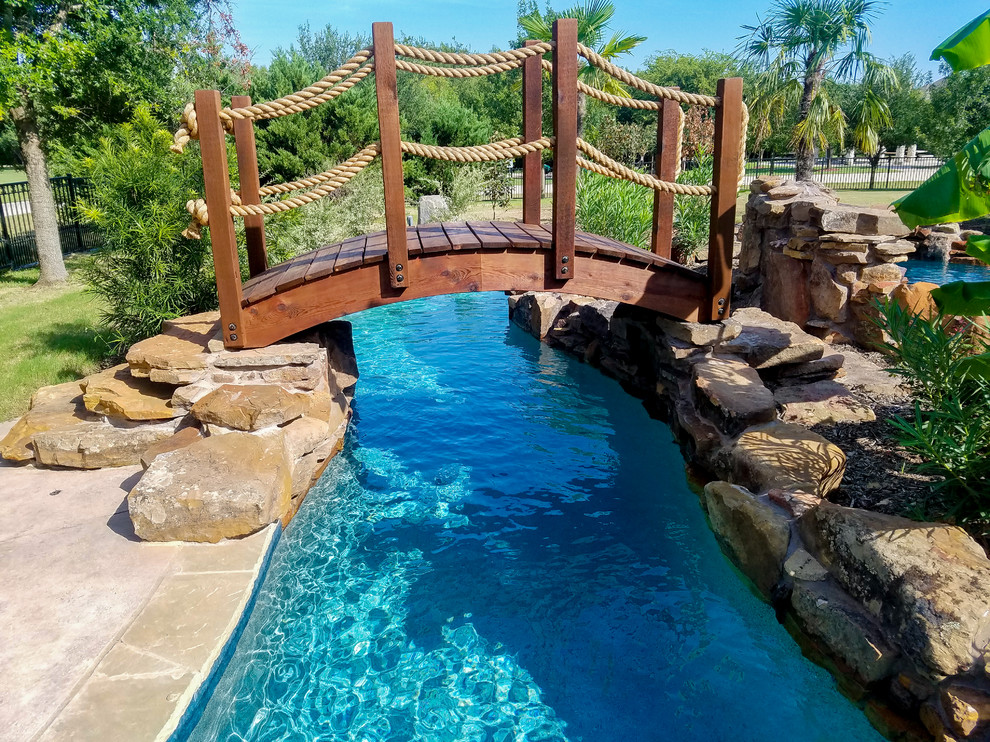 Photo of an expansive country backyard custom-shaped pool in Dallas with a water slide and natural stone pavers.