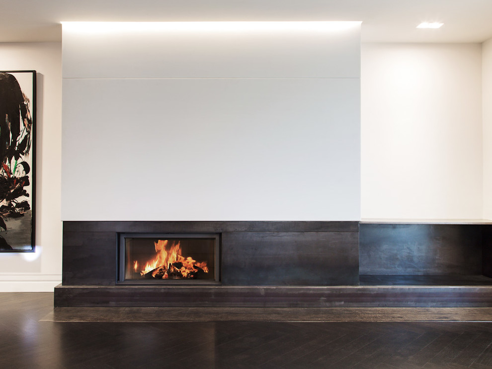 Large contemporary formal open concept living room in Montreal with white walls, dark hardwood floors, a ribbon fireplace and a metal fireplace surround.