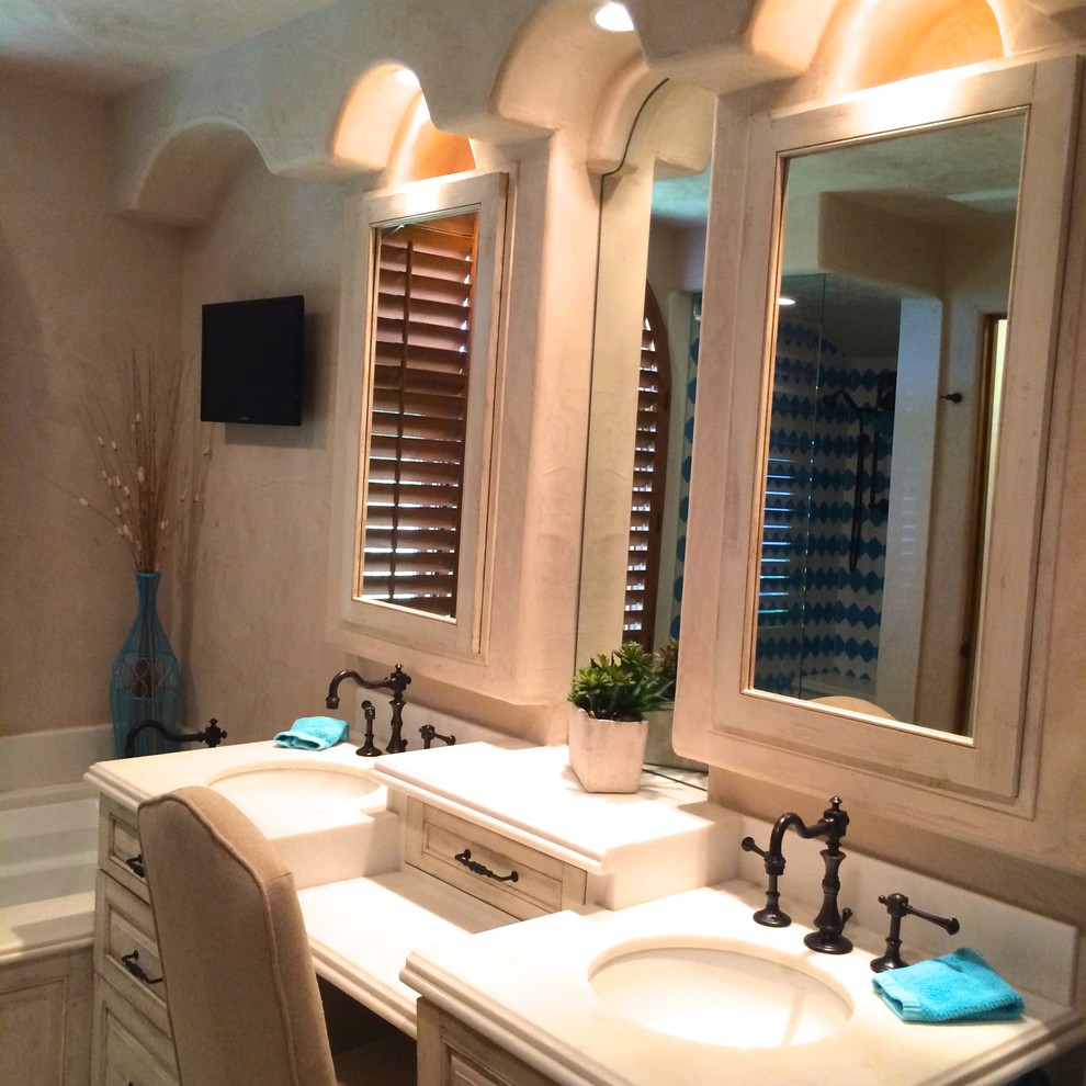 Inspiration for a mid-sized transitional master blue tile and porcelain tile ceramic tile and blue floor wet room remodel with raised-panel cabinets, distressed cabinets, an undermount tub, beige walls, an undermount sink, solid surface countertops and a hinged shower door