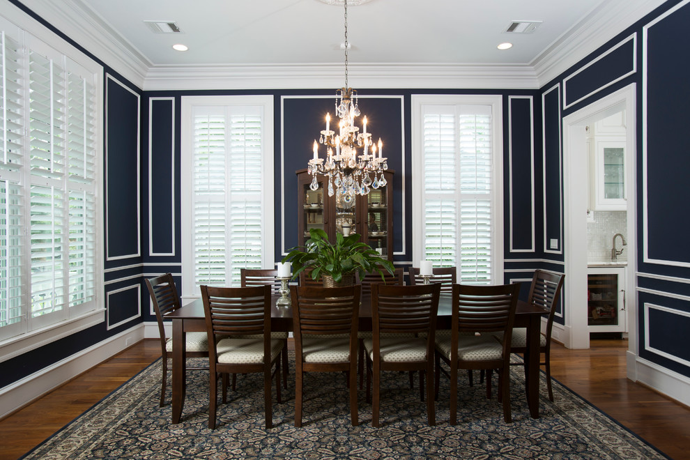 Geschlossenes, Geräumiges Klassisches Esszimmer ohne Kamin mit blauer Wandfarbe, dunklem Holzboden und braunem Boden in Houston