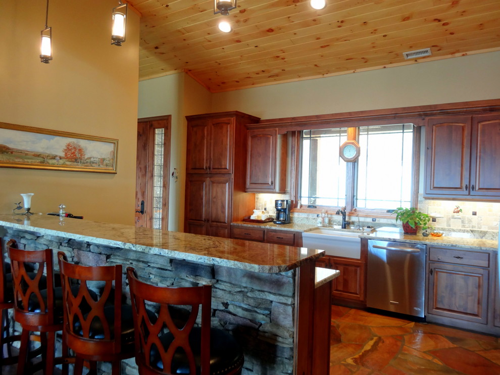 Mid-sized mountain style l-shaped slate floor open concept kitchen photo in Charlotte with a farmhouse sink, raised-panel cabinets, dark wood cabinets, granite countertops, multicolored backsplash, ceramic backsplash, stainless steel appliances and a peninsula
