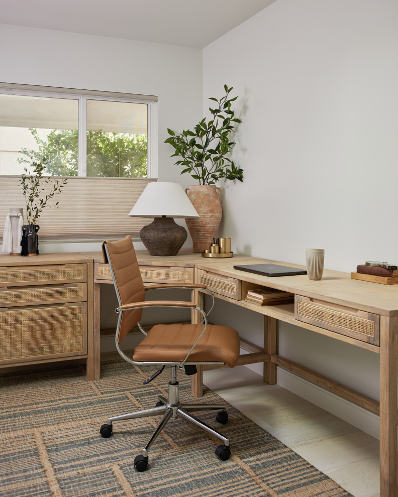 This is an example of a large midcentury home office in Los Angeles with white walls, light hardwood floors, a freestanding desk and beige floor.