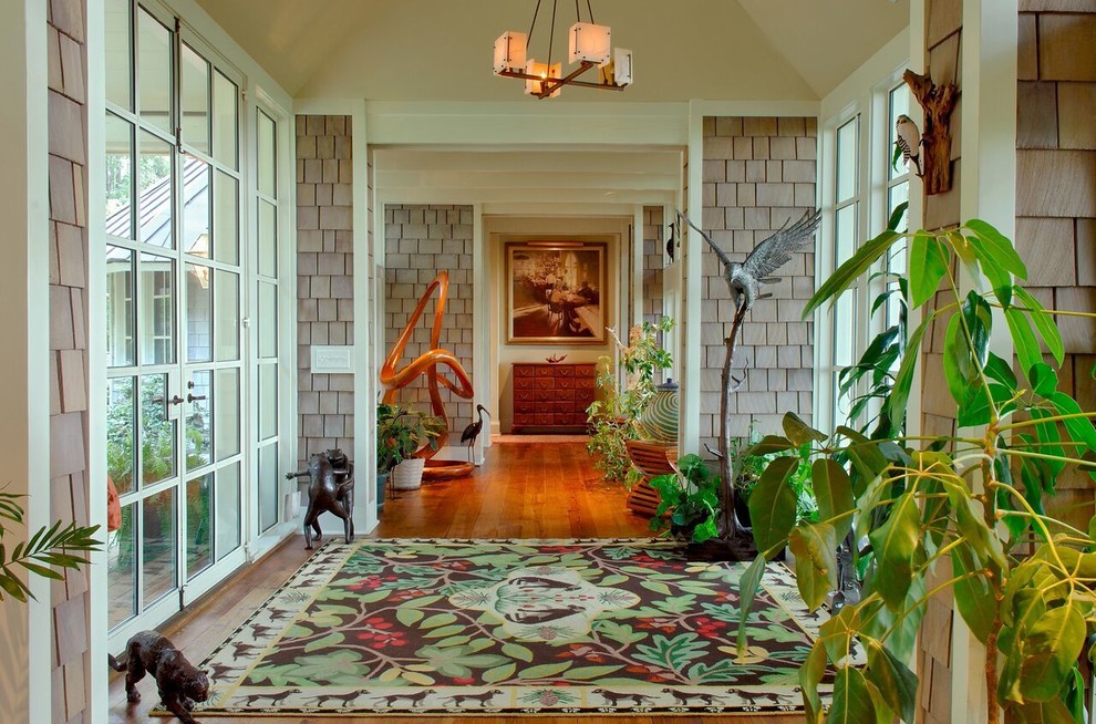 This is an example of a mid-sized tropical foyer in Charleston with medium hardwood floors, a glass front door, grey walls and a double front door.
