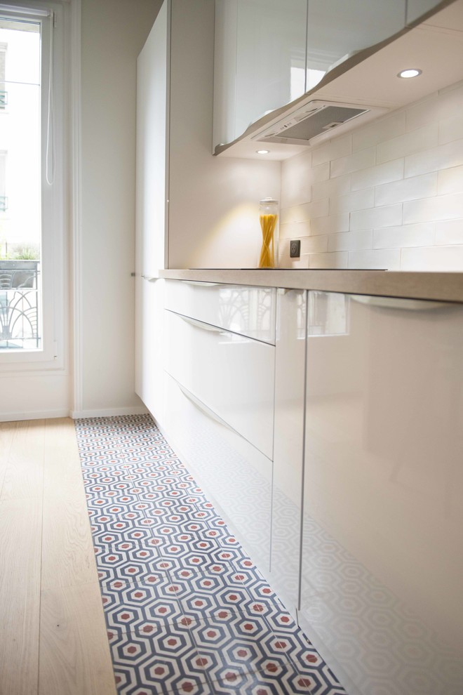 This is an example of a contemporary kitchen in Paris with cement tile splashback and ceramic floors.