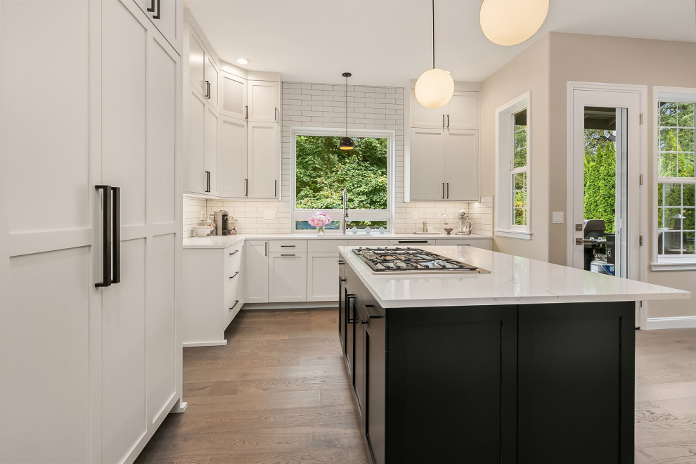 Kitchen - large transitional medium tone wood floor and gray floor kitchen idea in Seattle with an undermount sink, shaker cabinets, white cabinets, quartz countertops, white backsplash, subway tile backsplash, stainless steel appliances and white countertops