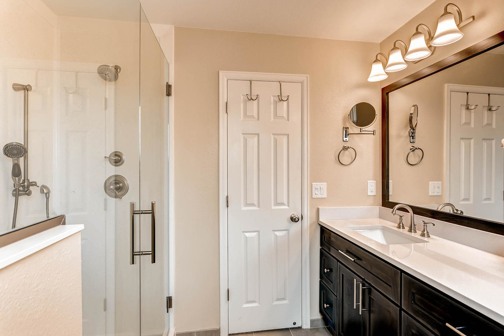Small transitional master cement tile ceramic tile doorless shower photo in Denver with shaker cabinets, dark wood cabinets, a one-piece toilet, beige walls, an undermount sink and quartz countertops