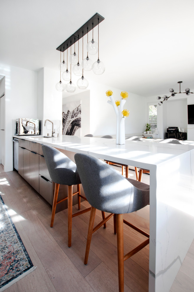 Inspiration for a large contemporary l-shaped eat-in kitchen in San Francisco with a single-bowl sink, white splashback, marble splashback, stainless steel appliances, medium hardwood floors, with island and white benchtop.