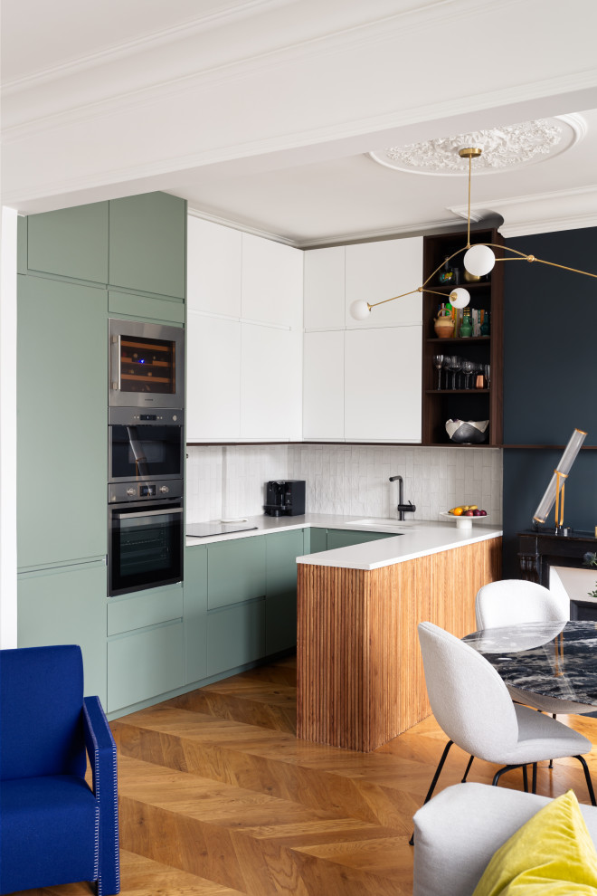 Mid-sized modern u-shaped open plan kitchen in Paris with an integrated sink, beaded inset cabinets, green cabinets, quartzite benchtops, white splashback, marble splashback, stainless steel appliances, medium hardwood floors, with island, white benchtop and wood.