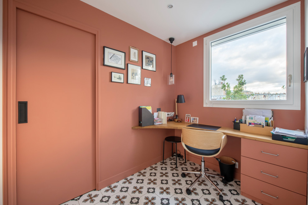 Mittelgroßes Modernes Arbeitszimmer ohne Kamin mit Arbeitsplatz, roter Wandfarbe, Keramikboden, Einbau-Schreibtisch und buntem Boden in Paris