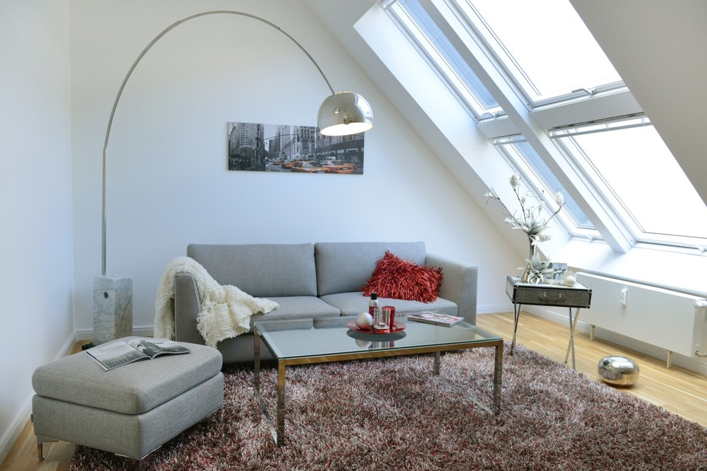 Photo of a small scandinavian enclosed family room in Berlin with white walls, light hardwood floors and no fireplace.