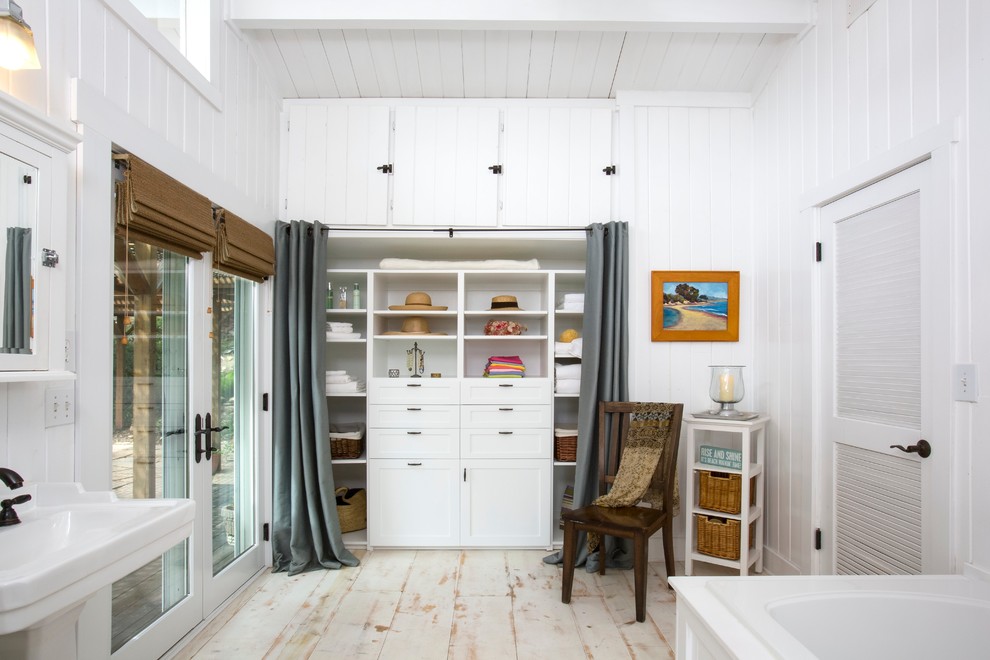 This is an example of a beach style built-in wardrobe in Santa Barbara with painted wood floors.
