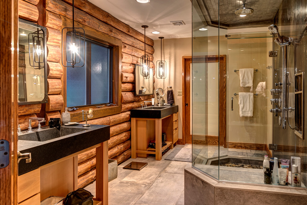 Example of a large mountain style master gray floor bathroom design with open cabinets, brown cabinets, beige walls, an integrated sink, a hinged shower door and gray countertops