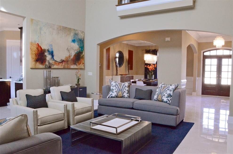 Large transitional open concept family room in Charlotte with beige walls, a standard fireplace, a tile fireplace surround, a wall-mounted tv, white floor and porcelain floors.