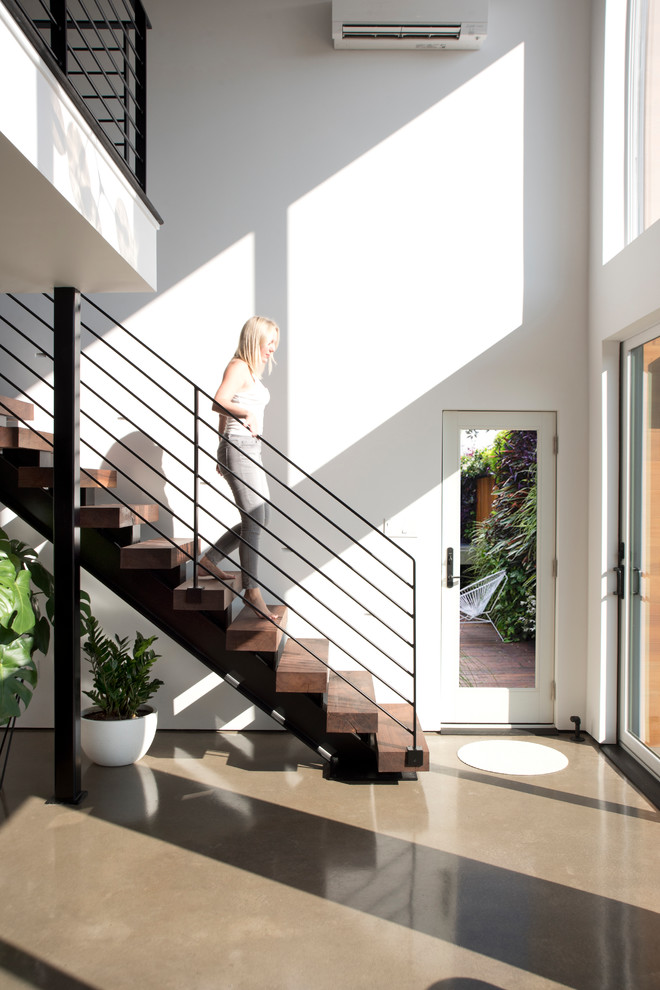 Inspiration for a small scandinavian wood straight staircase in New York with metal railing.