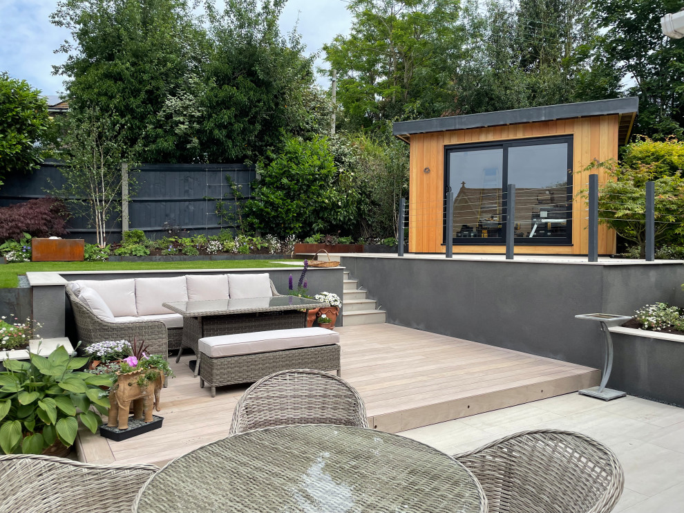 Contemporary back garden for summer in West Midlands with a retaining wall.