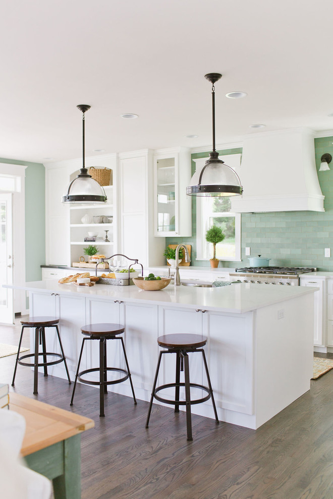 Inspiration for a large mediterranean l-shaped open plan kitchen in Minneapolis with beaded inset cabinets, white cabinets, marble benchtops, green splashback, ceramic splashback, stainless steel appliances, dark hardwood floors, with island, brown floor and white benchtop.