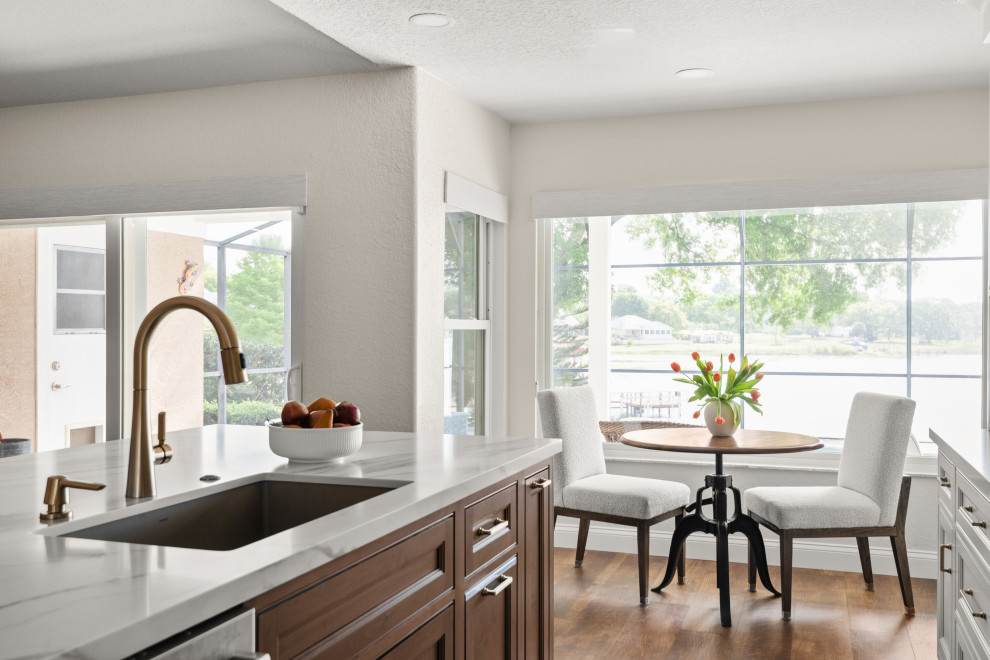 Transitional kitchen photo in Orlando with white cabinets, quartzite countertops, gray backsplash, ceramic backsplash, an island and white countertops