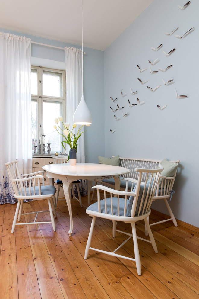 Inspiration for a mid-sized transitional dining room in Berlin with blue walls, medium hardwood floors and brown floor.