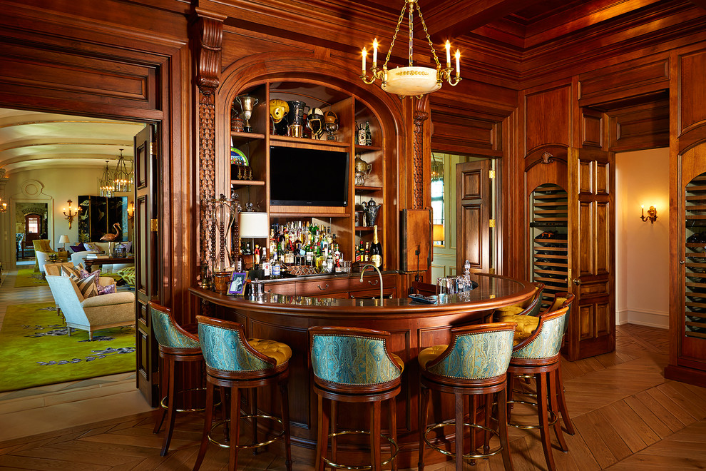 Photo of a mid-sized traditional u-shaped seated home bar in Tampa with dark hardwood floors, recessed-panel cabinets, dark wood cabinets, wood benchtops, grey splashback, mirror splashback, brown floor and brown benchtop.